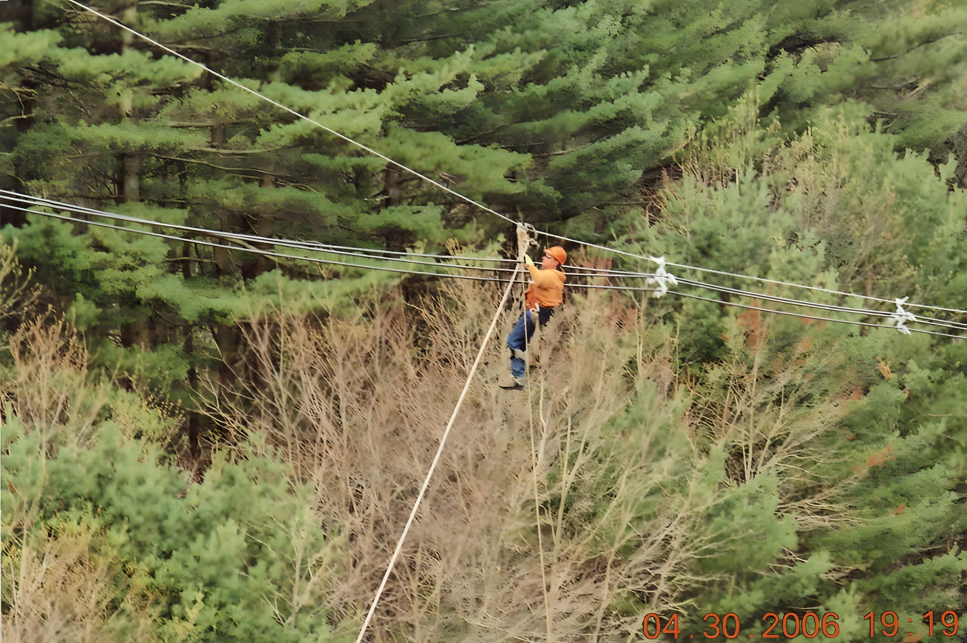 Lineman hand-traveling conductor in transmission ROW — Ryan McDonough's first field job, 2006